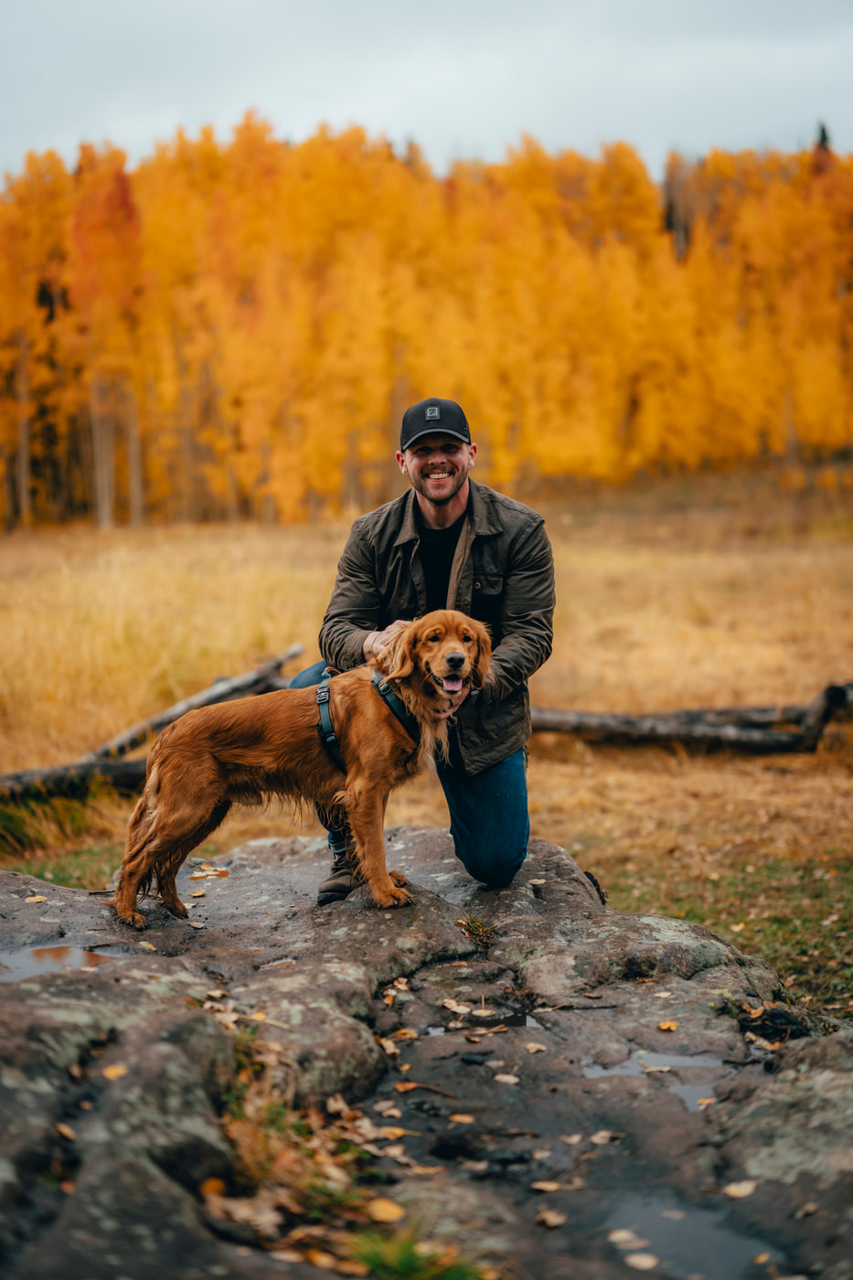 Max kneeling with his golden retriever among Colorado fall aspens