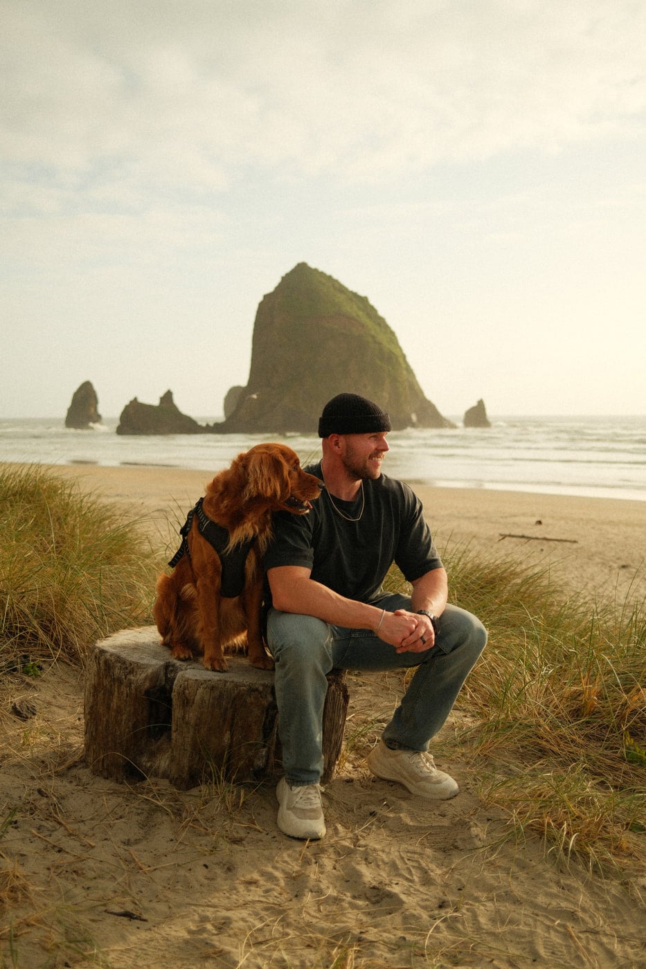 Max and his golden retriever on the beach at Haystack Rock
