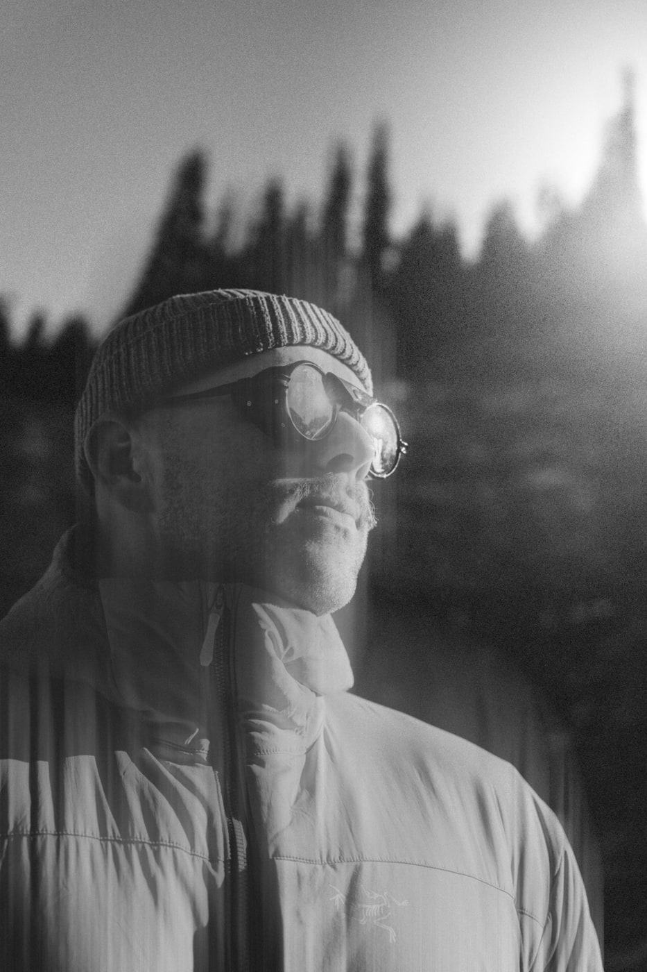 Black and white portrait of Max in a beanie and sunglasses at dusk