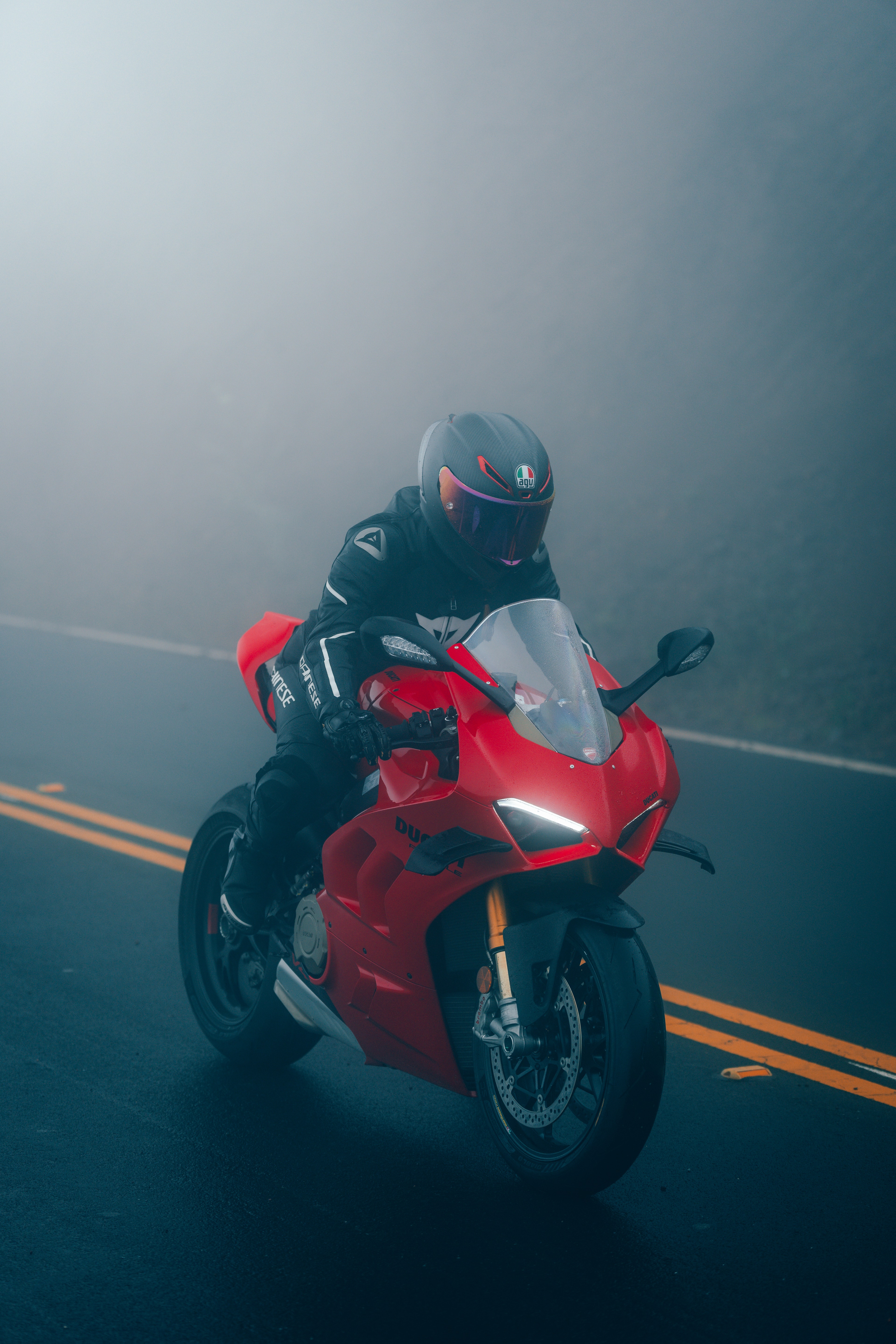 Ducati Panigale V4S rider in heavy fog, head-on portrait, AGV carbon helmet