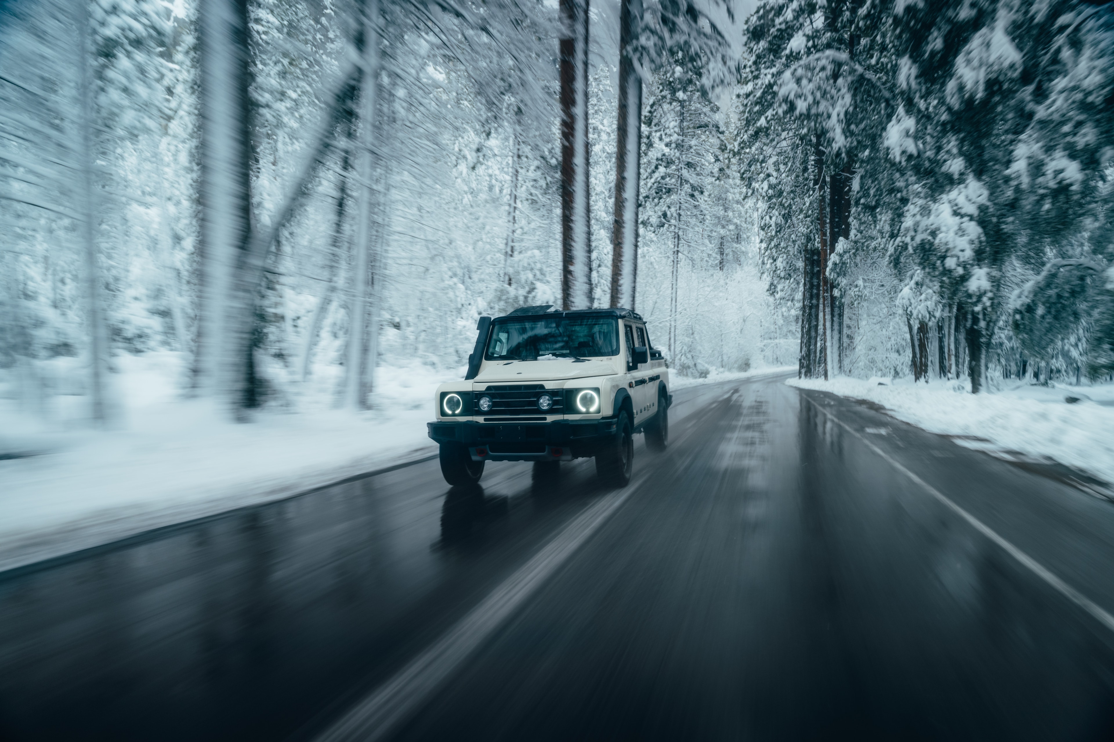 INEOS Grenadier Quartermaster in motion on a wet snowy road through the forest