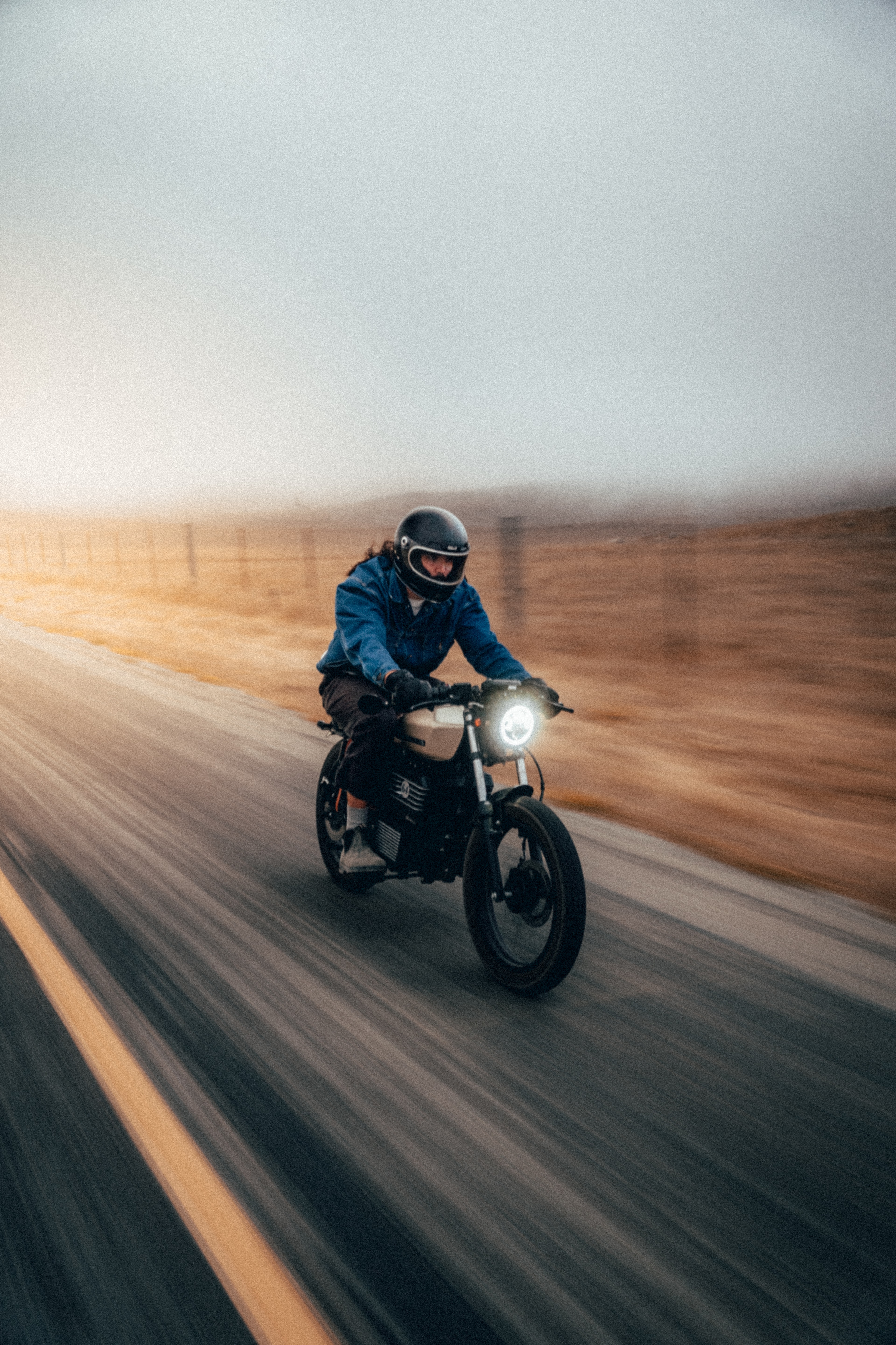 Rider on the Beachman cafe racer head-on in motion on a foggy coast road