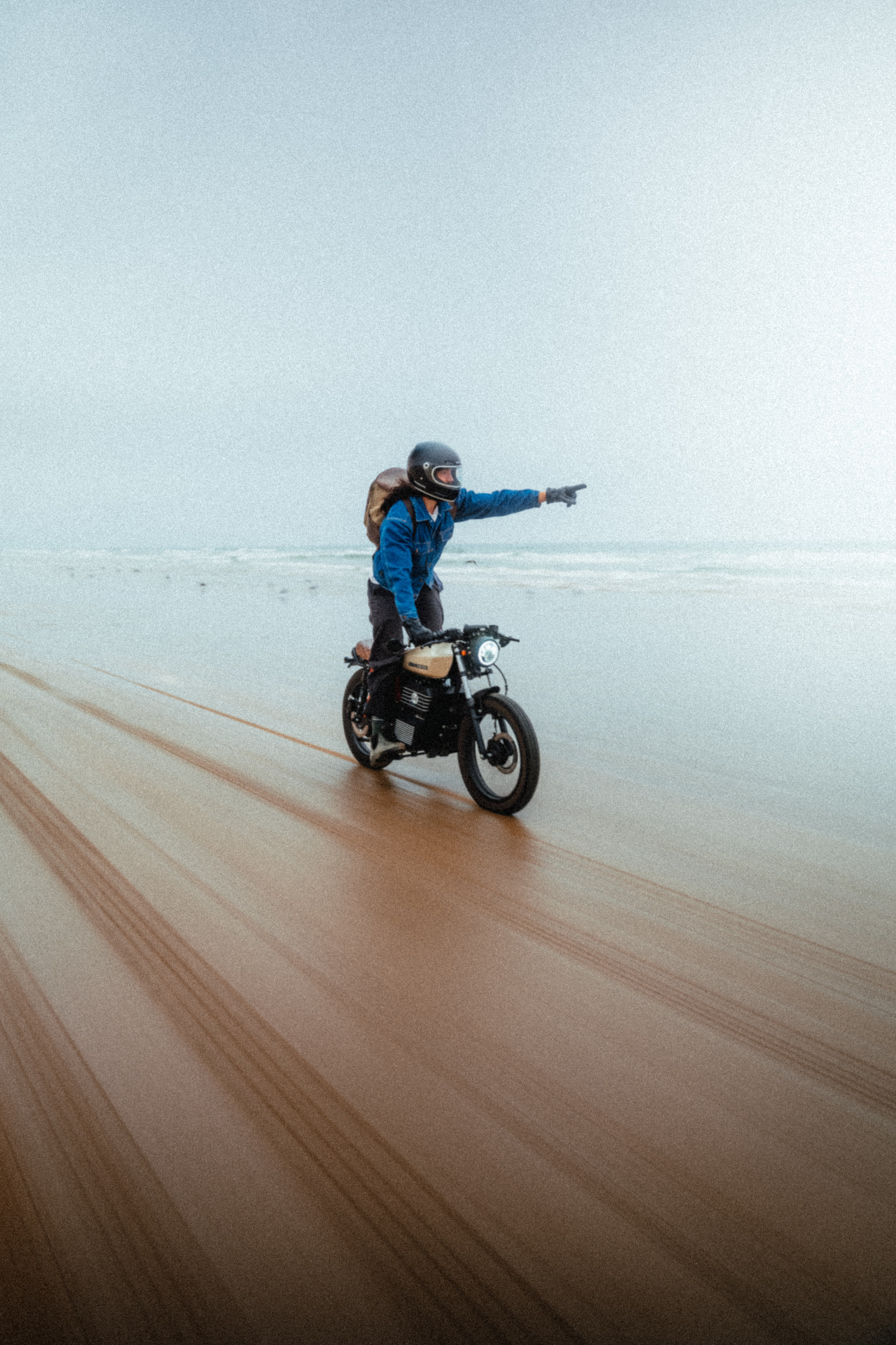 Rider on the Beachman pointing down the beach, in motion
