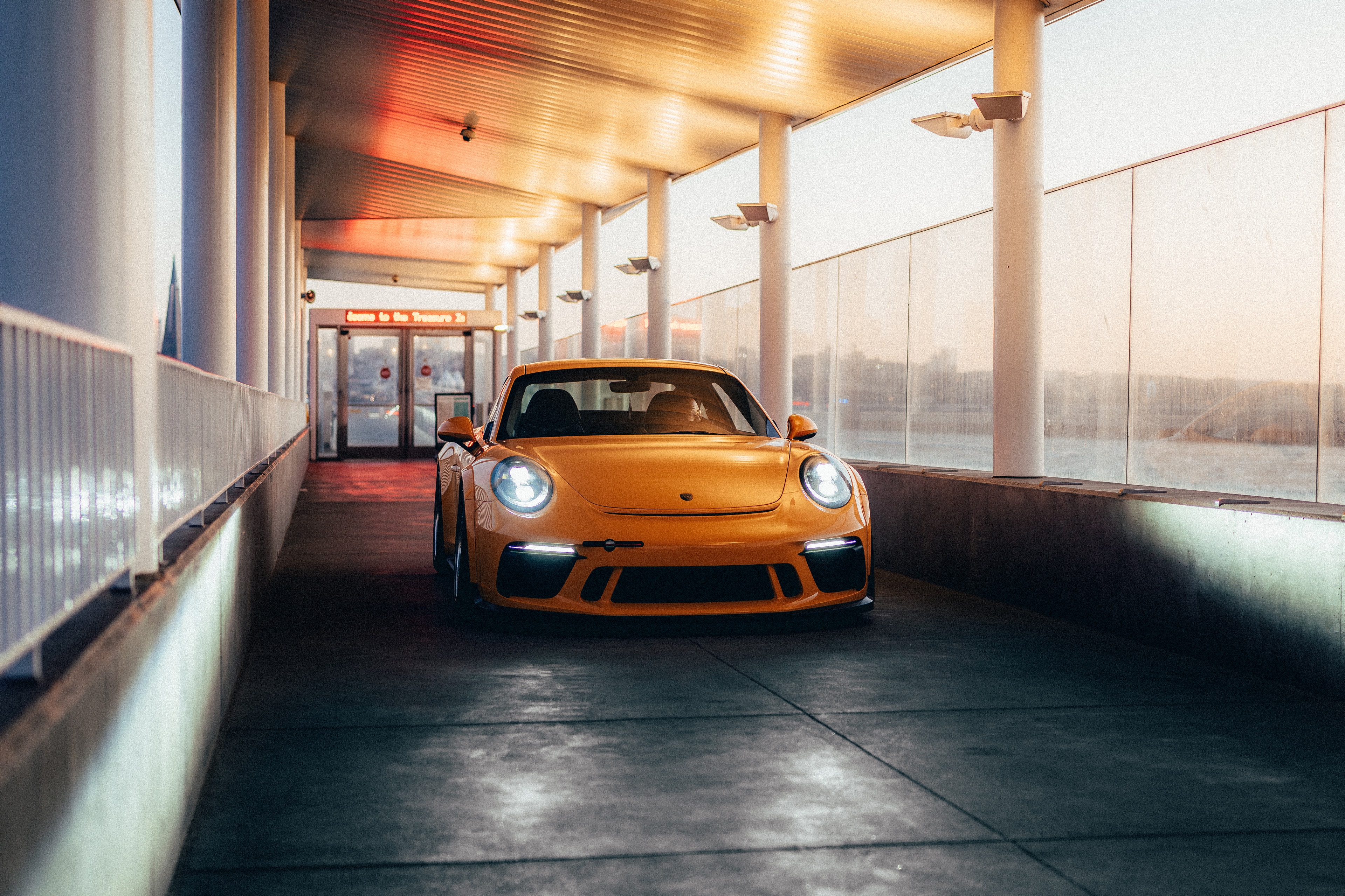 911 GT3 on Treasure Island, framed by a covered concrete structure at golden hour